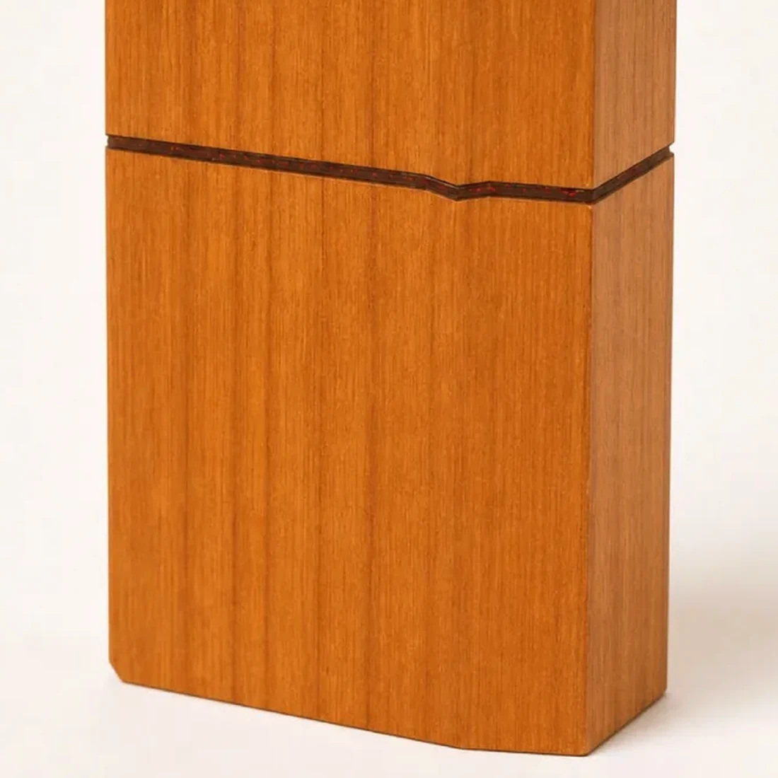 Close detail of the faceted lid split by a thin red inlay seam