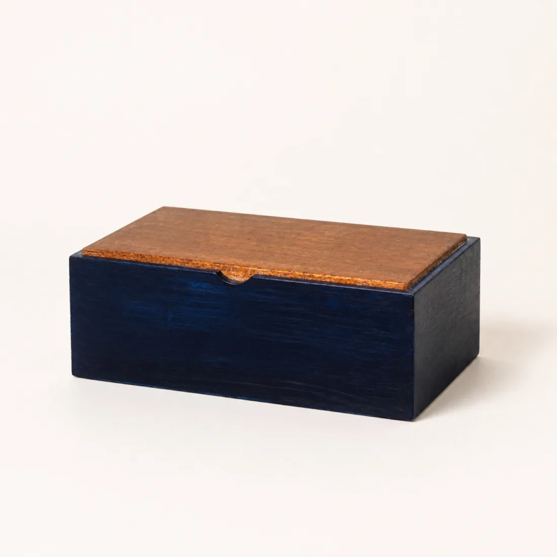 Indigo-dyed box with a natural cherry wood lid, grain reading through the colour