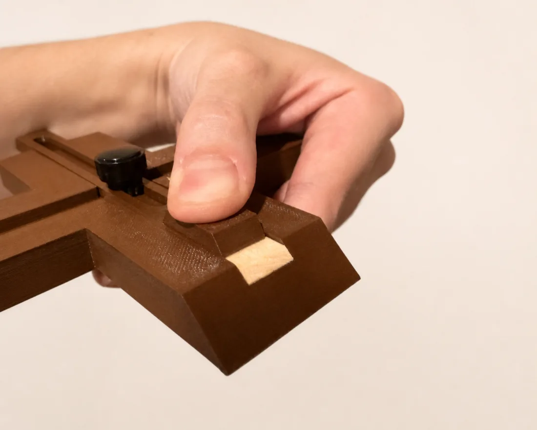 Hand adjusting the crosscut jig stop against a wood strip