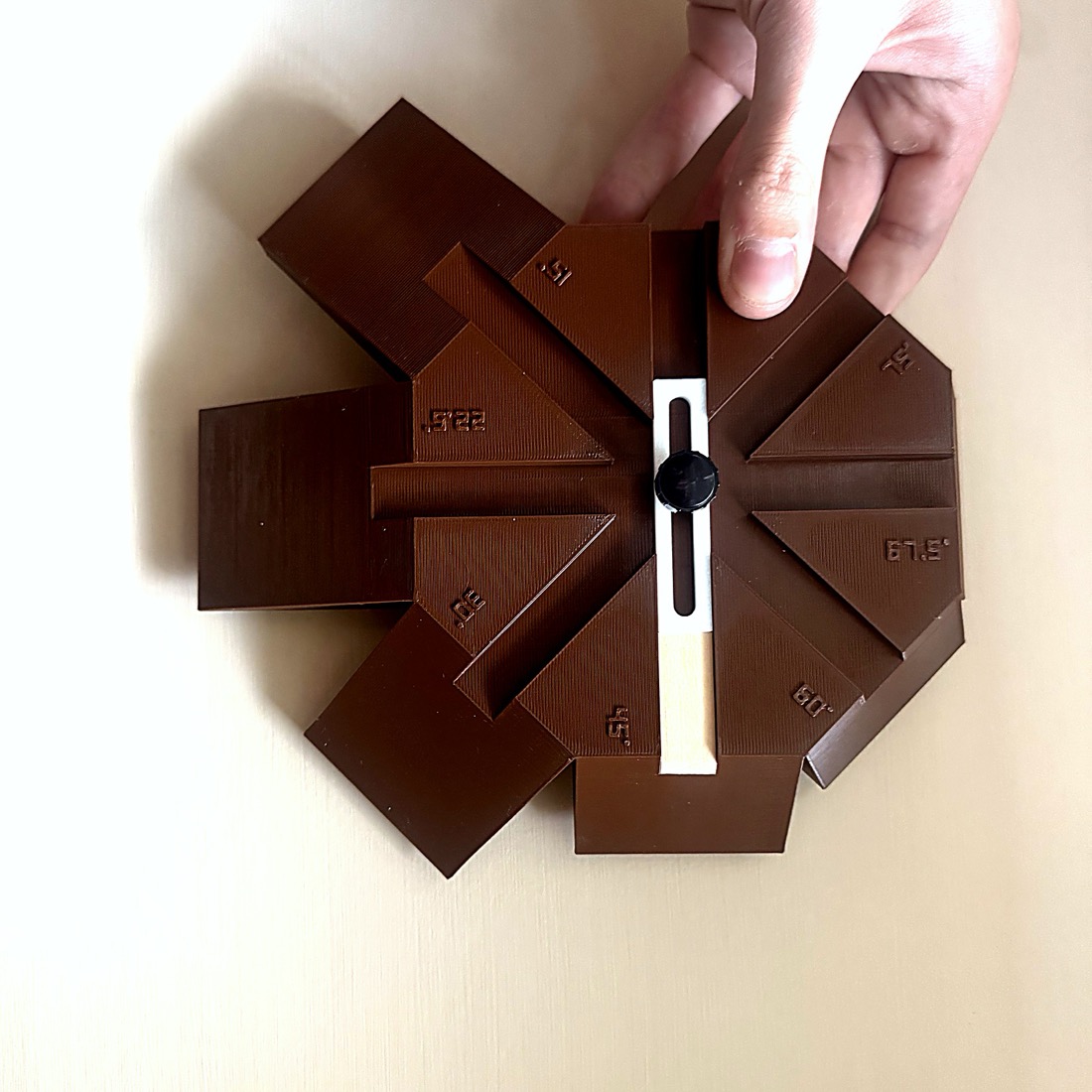 Eight-way kumiko star jig printed in brown PETG, every angle from 15 to 75 degrees embossed on the body, with a white sliding stop